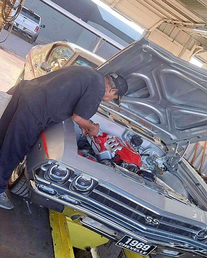 One of our techs under the hood of a customer's 1969 Chevelle in the bay