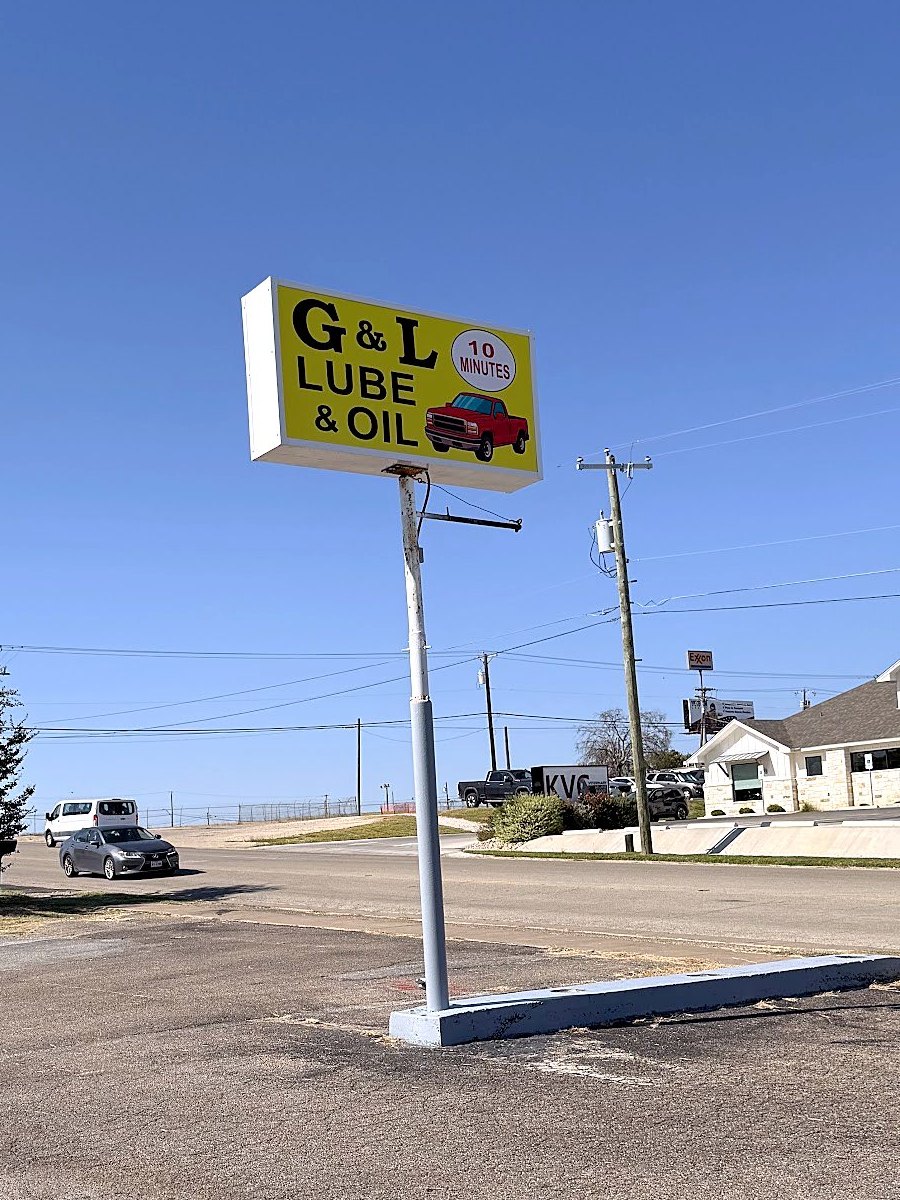 The roadside sign with the 10 minutes badge and a red pickup